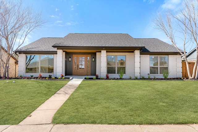 view of front facade featuring brick siding, roof with shingles, and a front lawn