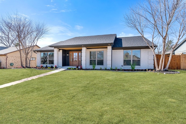 view of front of property featuring a front lawn, fence, brick siding, and a shingled roof