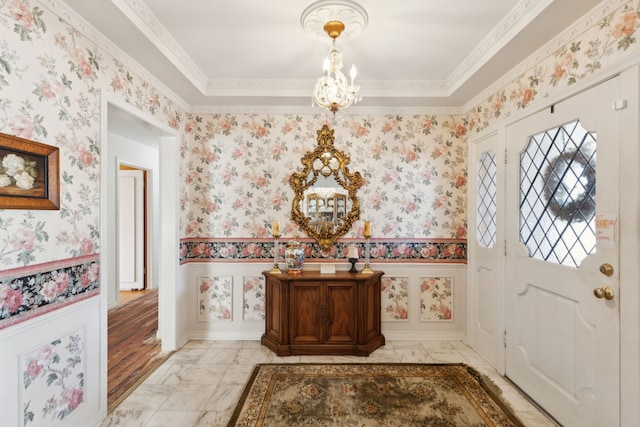 foyer featuring wainscoting, wallpapered walls, and an inviting chandelier