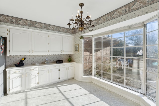 interior space with an inviting chandelier and wallpapered walls