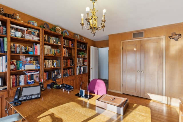 home office with visible vents, an inviting chandelier, and wood finished floors