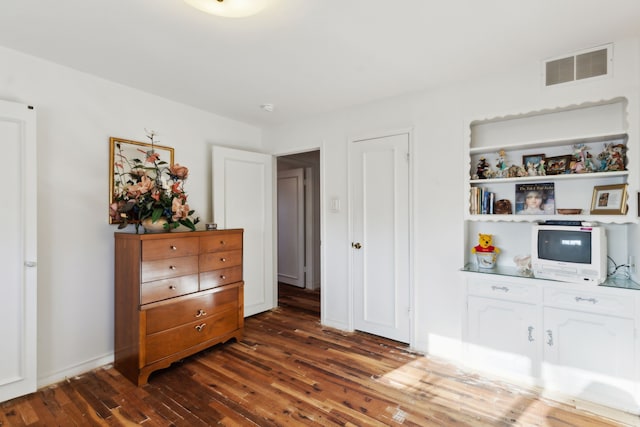 bedroom with dark wood finished floors, baseboards, and visible vents