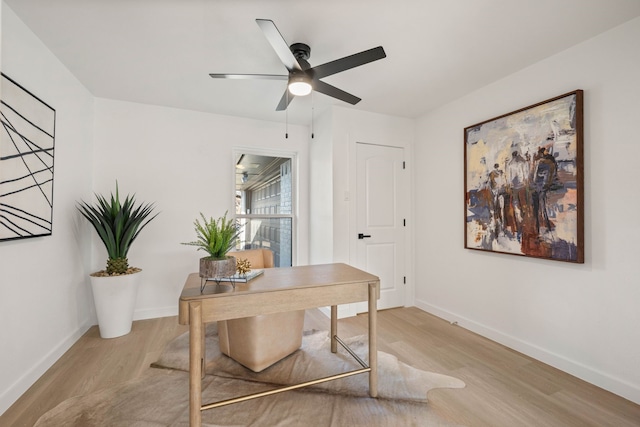 home office featuring light wood finished floors, ceiling fan, and baseboards