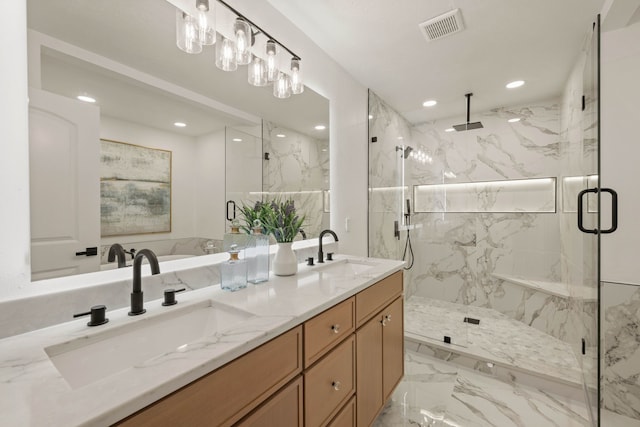 bathroom featuring a marble finish shower, visible vents, marble finish floor, and a sink