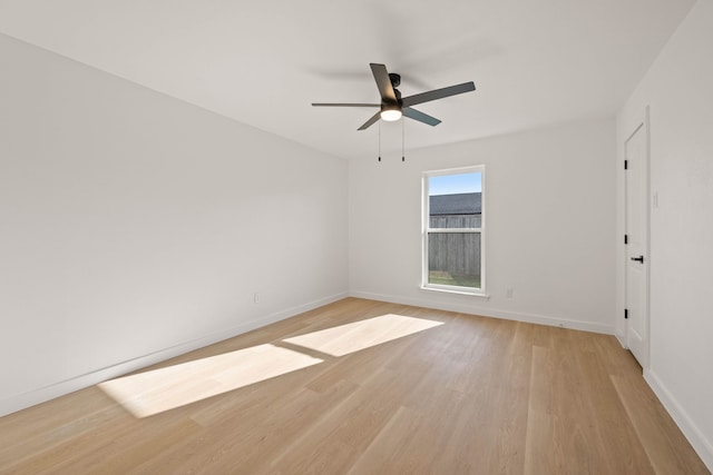 empty room featuring ceiling fan, light wood-type flooring, and baseboards