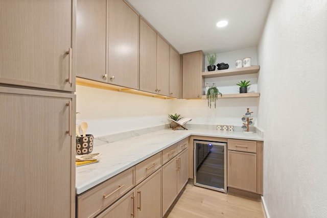 kitchen with beverage cooler, light brown cabinetry, light stone counters, light wood-style floors, and open shelves