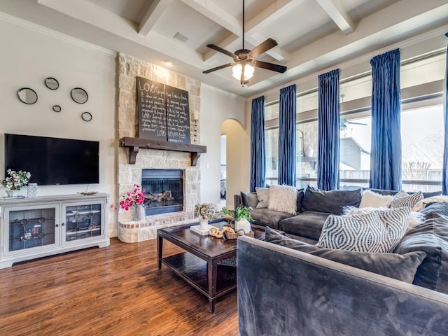 living area featuring wood finished floors, a healthy amount of sunlight, arched walkways, and coffered ceiling