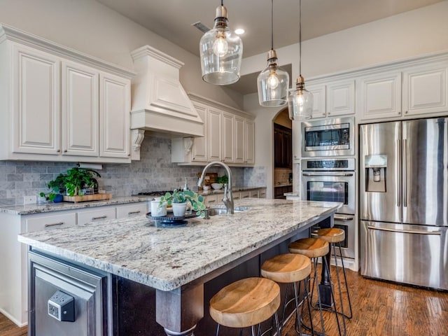 kitchen featuring arched walkways, white cabinets, appliances with stainless steel finishes, and tasteful backsplash