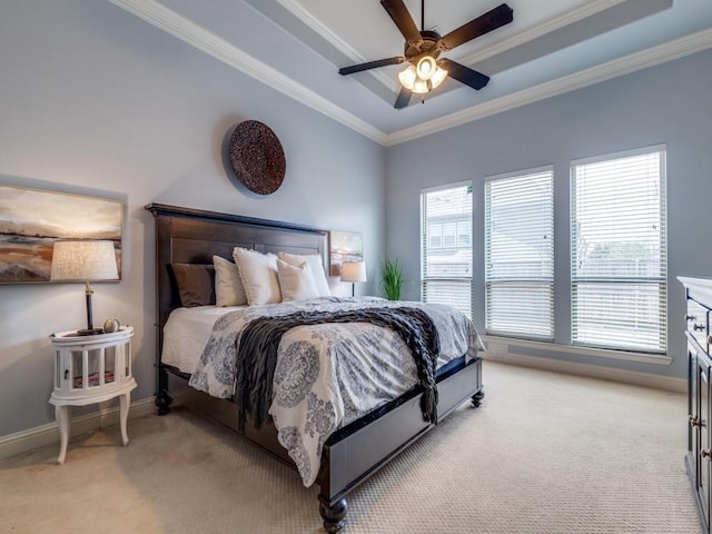 bedroom featuring baseboards, a raised ceiling, light colored carpet, and ornamental molding