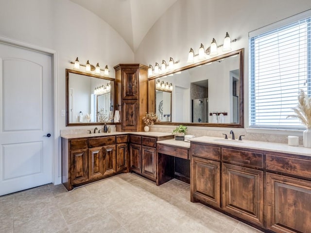 full bath featuring lofted ceiling, double vanity, a stall shower, tile patterned floors, and a sink