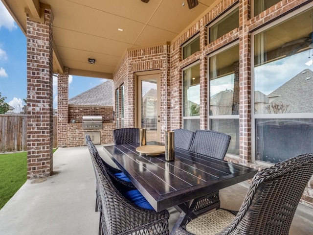 view of patio with area for grilling, outdoor dining area, and fence