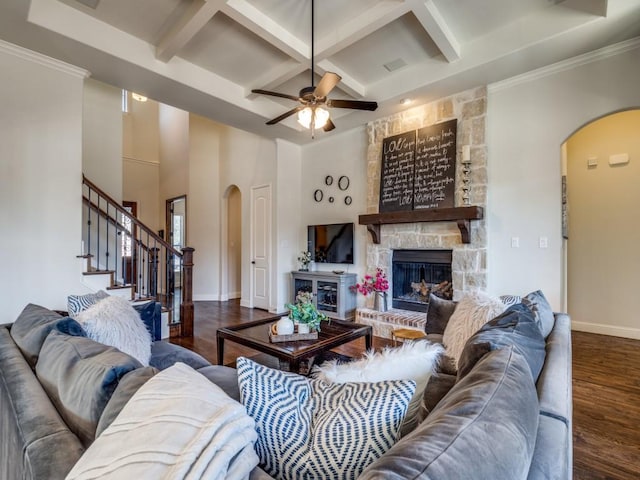 living room with baseboards, a fireplace, wood finished floors, arched walkways, and coffered ceiling