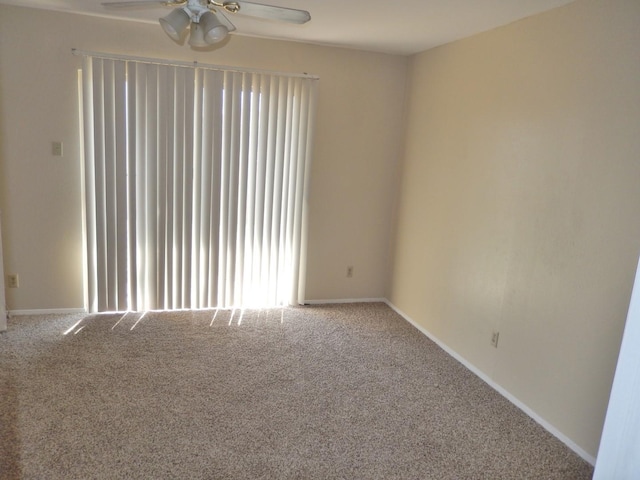 carpeted spare room with baseboards and ceiling fan