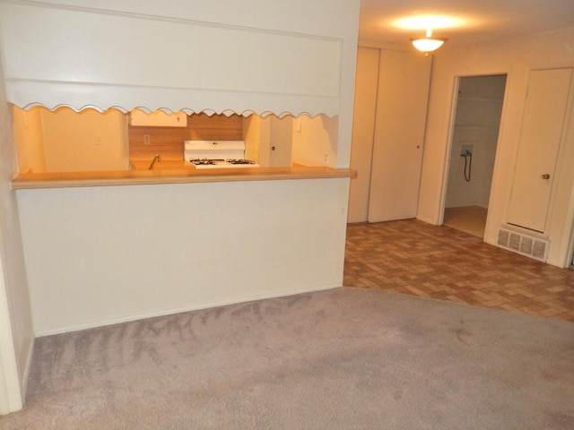 kitchen with visible vents, range, and carpet