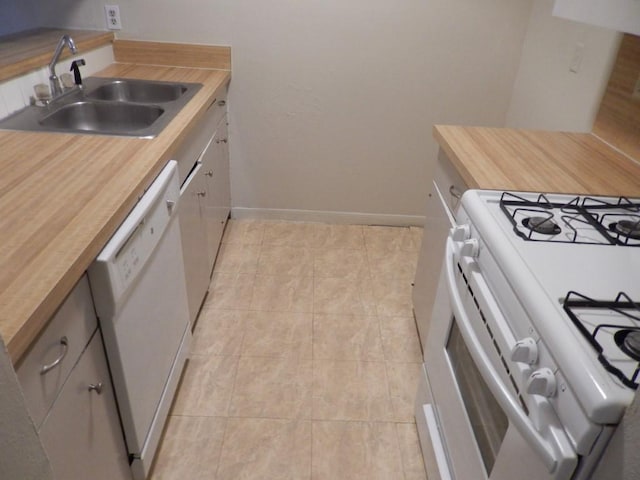 kitchen featuring white appliances, light tile patterned floors, baseboards, wooden counters, and a sink