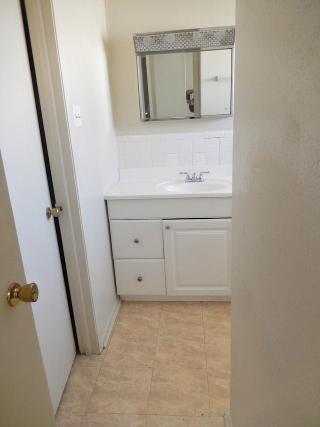 bathroom featuring tile patterned flooring, decorative backsplash, and vanity