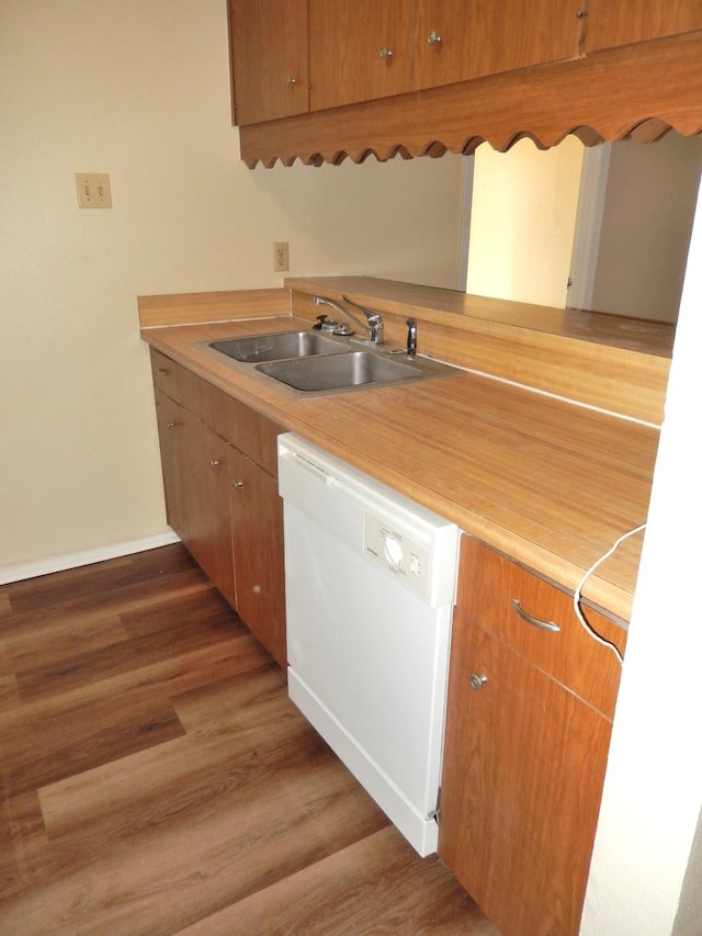 kitchen featuring wood finished floors, a sink, light countertops, dishwasher, and brown cabinets