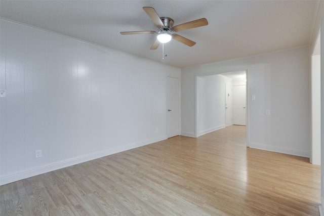 spare room with a ceiling fan, light wood-type flooring, and baseboards