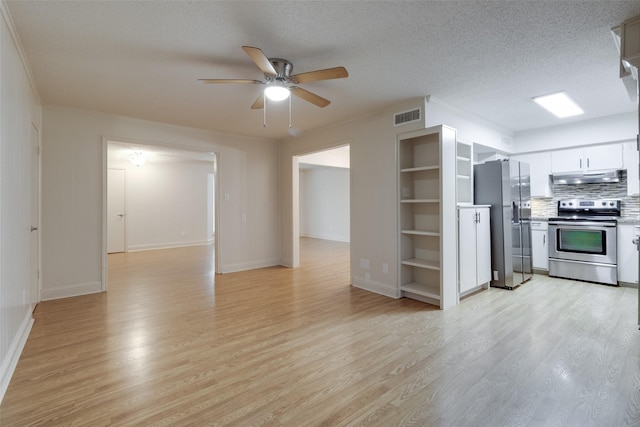 kitchen featuring visible vents, under cabinet range hood, a textured ceiling, light wood-style floors, and appliances with stainless steel finishes