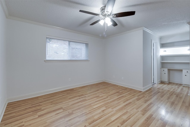 spare room featuring baseboards, light wood finished floors, built in study area, ornamental molding, and a textured ceiling