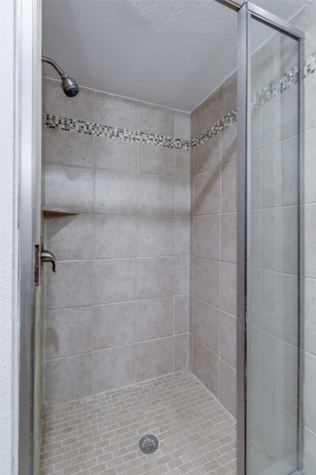 bathroom featuring a stall shower and a textured ceiling