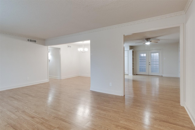 unfurnished room with light wood finished floors, visible vents, crown molding, ceiling fan with notable chandelier, and french doors