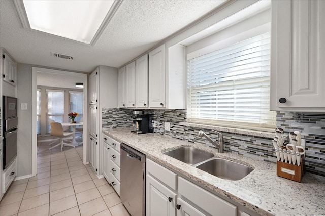 kitchen featuring visible vents, a sink, white cabinetry, wall oven, and dishwasher