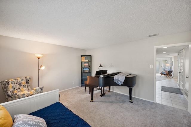 interior space featuring visible vents, a textured ceiling, and carpet flooring