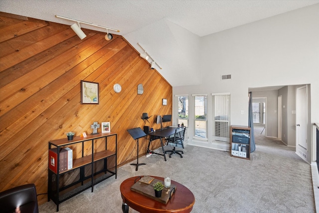 office space featuring track lighting, carpet, visible vents, and a textured ceiling