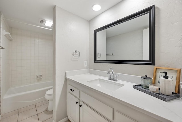 bathroom featuring tile patterned flooring, toilet, vanity, a textured wall, and washtub / shower combination