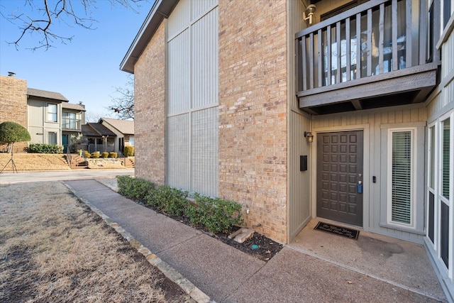 view of exterior entry featuring brick siding