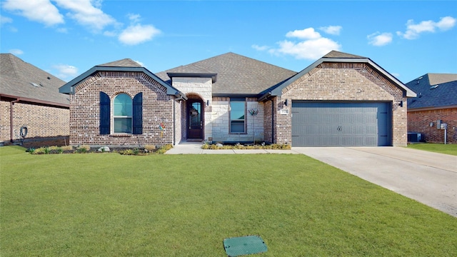 french country style house featuring brick siding, a shingled roof, a front yard, a garage, and driveway