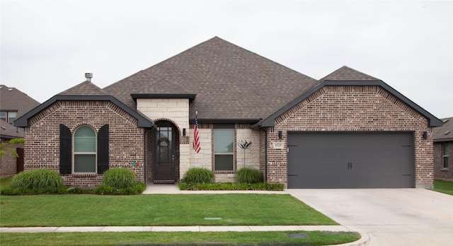 1525 Wagon Wheel Way, Krum, TX 76249 - french country home featuring brick siding, a garage, concrete driveway, a front lawn, and roof with shingles