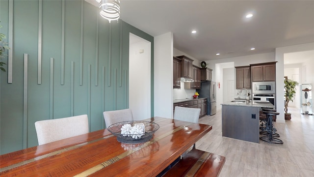 dining space with light wood-style flooring and recessed lighting