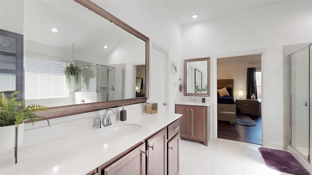 ensuite bathroom with a shower stall, connected bathroom, plenty of natural light, and a sink