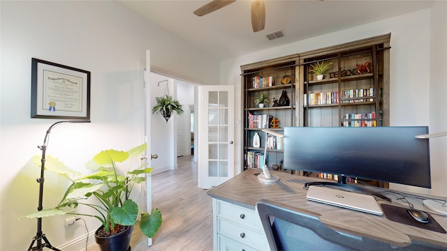 home office with visible vents, light wood-style flooring, a ceiling fan, and french doors