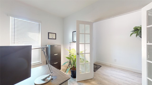 office area with french doors, baseboards, and light wood-style floors