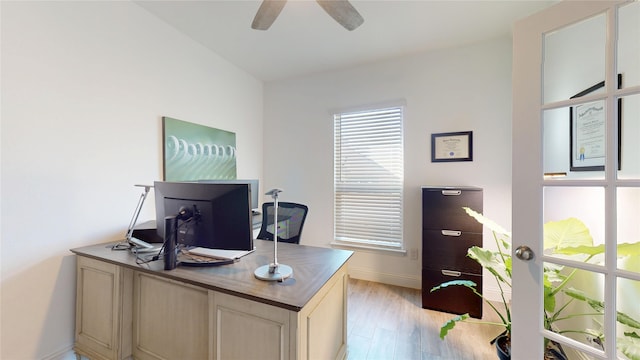 office area featuring a ceiling fan, baseboards, and light wood finished floors