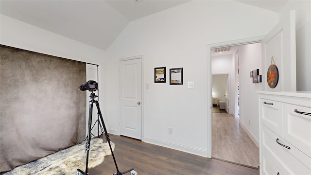 bedroom with lofted ceiling, visible vents, dark wood-style flooring, and baseboards