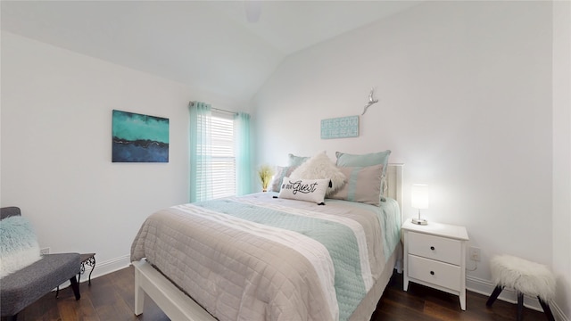 bedroom with vaulted ceiling, wood finished floors, and baseboards