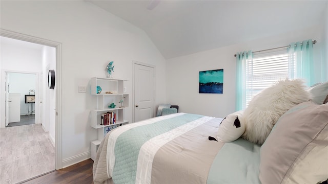 bedroom with ceiling fan, wood finished floors, baseboards, and vaulted ceiling