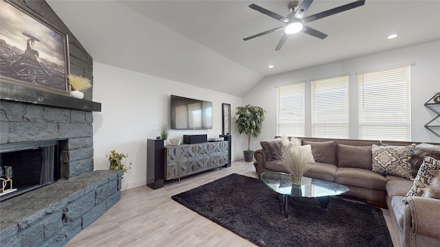 living room featuring recessed lighting, light wood-style floors, a stone fireplace, ceiling fan, and vaulted ceiling