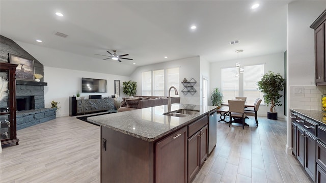 kitchen with visible vents, a ceiling fan, a sink, dark stone countertops, and stainless steel dishwasher