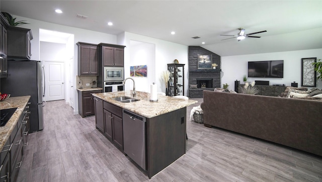 1525 Wagon Wheel Way, Krum, TX 76249 - kitchen with a sink, stainless steel appliances, ceiling fan, a fireplace, and open floor plan