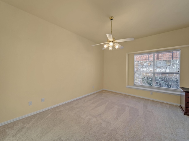 empty room featuring baseboards, light colored carpet, and ceiling fan