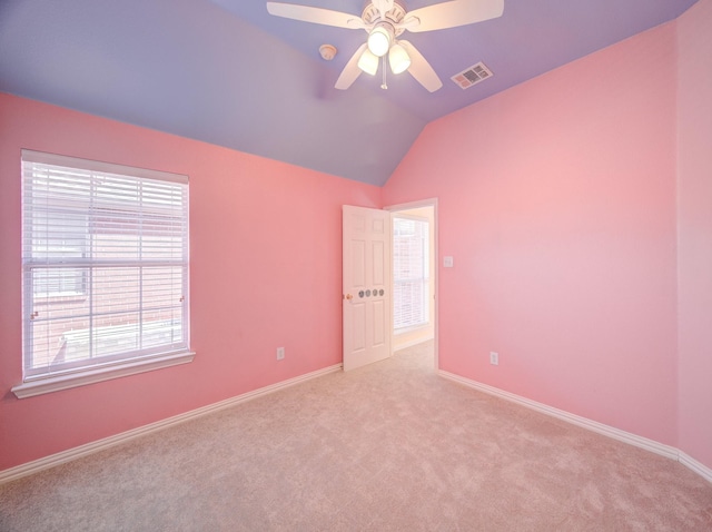 carpeted spare room featuring visible vents, ceiling fan, baseboards, and lofted ceiling