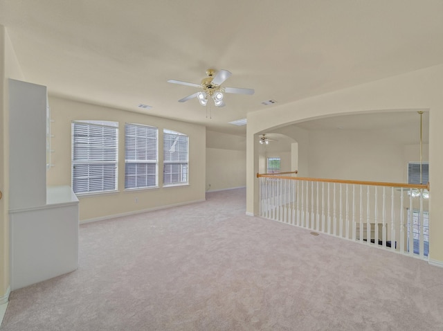 carpeted empty room featuring visible vents and ceiling fan