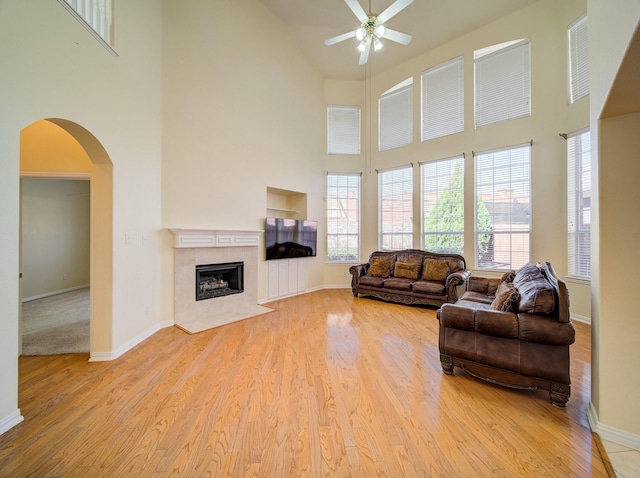 living room with light wood-style floors, baseboards, and a premium fireplace