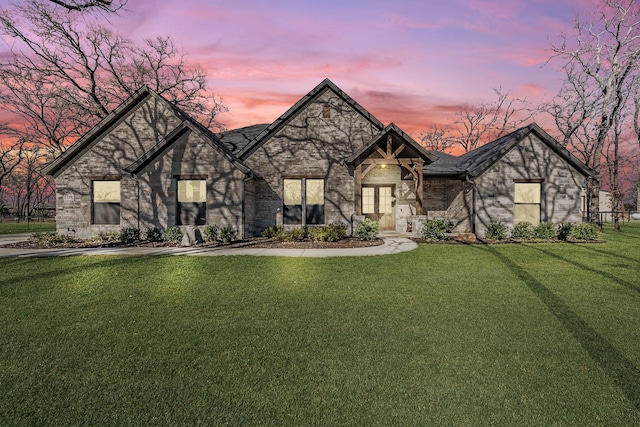 view of front of property featuring a lawn and brick siding