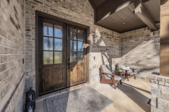 view of exterior entry featuring brick siding